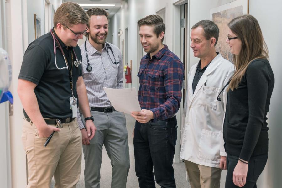 A preceptor talks to a group of residents.